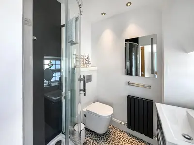 a bathroom with a toilet and a glass shower at Bruce Cottage in Whithorn