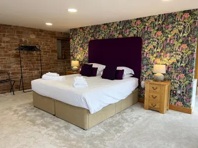 a bedroom with a large bed with purple pillows at Blencathra Barn in Penrith