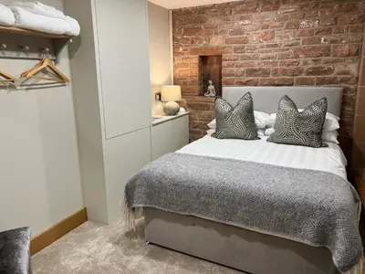 a bedroom with a bed with a brick wall at Blencathra Barn in Penrith