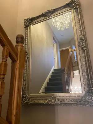 a mirror on the wall with a staircase in a house at Cumberland House in Cockermouth