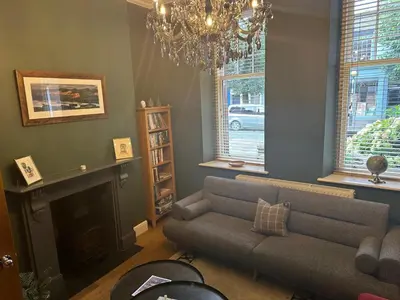 a living room with a couch and a fireplace at Cumberland House in Cockermouth