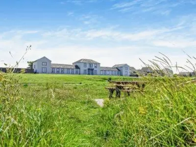 a large house in the middle of a field at North Lodge Retreat Allonby in Maryport