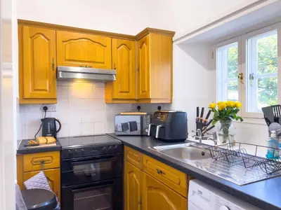 a kitchen with wooden cabinets and a sink at North Lodge Retreat Allonby in Maryport