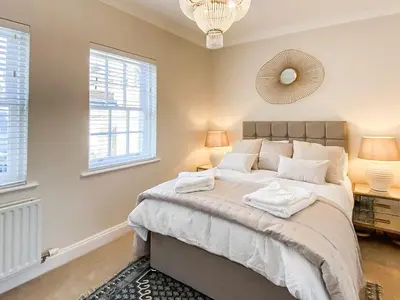 a bedroom with a large bed and two windows at The Guards Quarters - Uk47594 in Silloth