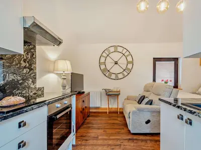 a kitchen and living room with a large clock on the wall at 1 Bed in Allonby 95499 in Allonby
