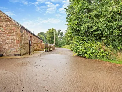 an empty dirt road next to a brick building at 1 Bed in Allonby 95499 in Allonby