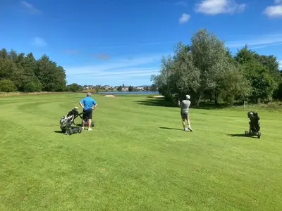 a group of people playing golf on a golf course at Stable Cottage in Lockerbie