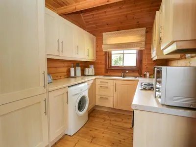 a kitchen with a washer and dryer in a cabin at Glenisle in Dalbeattie