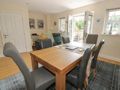 a dining room with a wooden table and chairs at Ptarmigan in Newton Stewart
