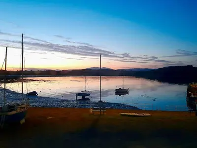 a group of boats sitting on the water at sunset at Ptarmigan in Newton Stewart