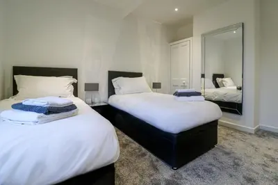 a bedroom with two beds and a mirror at Marchfield Promenade View in Prestwick