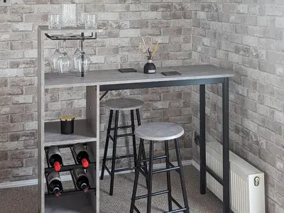 a table with two stools next to a brick wall at Zion's Retreat in Plumbland