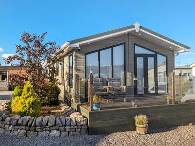 a small house with a deck with glass windows at Zion's Retreat in Plumbland