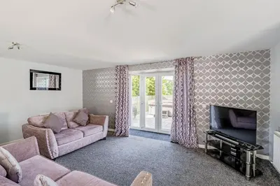 a living room with a couch and a fireplace at Auchenlarie Courtyard No 1 in Gatehouse of Fleet