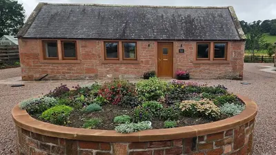 a small house with a garden in front of it at Country cottage with garden, views & games room in Dumfries