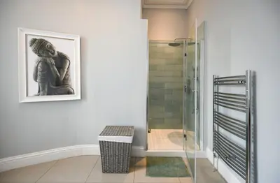 a bathroom with a shower and a picture on the wall at Ayrbados - 4 bed townhouse in Ayr in Ayr