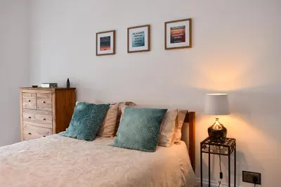a bedroom with a bed with two blue pillows at Ayrbados - 4 bed townhouse in Ayr in Ayr