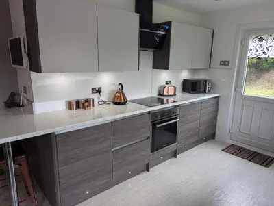 a kitchen with white cabinets and a counter top at Doonhill in Portpatrick in Portpatrick