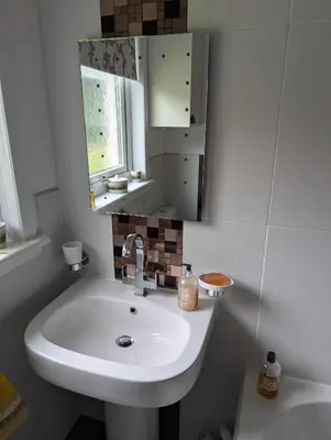 a bathroom with a white sink and a mirror at Doonhill in Portpatrick in Portpatrick