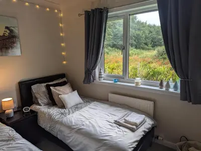 a bedroom with a bed in front of a window at Doonhill in Portpatrick in Portpatrick