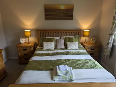 a bedroom with two beds with green and white sheets at Doonhill in Portpatrick in Portpatrick