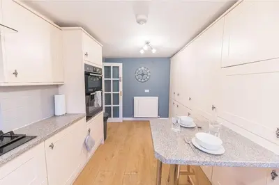 a kitchen with white cabinets and a counter top at 4BR Holiday Home Steps from Keswick Town Centre in Keswick