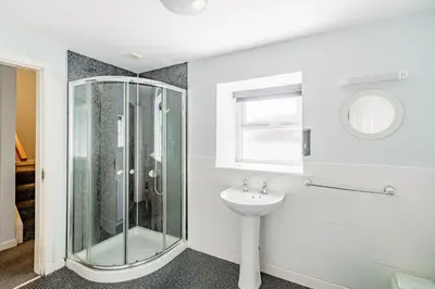a bathroom with a glass shower and a sink at Auchenlarie Courtyard No 3 in Gatehouse of Fleet