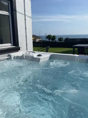 a swimming pool with blue water in a house at Auchenlarie Farmhouse in Gatehouse of Fleet