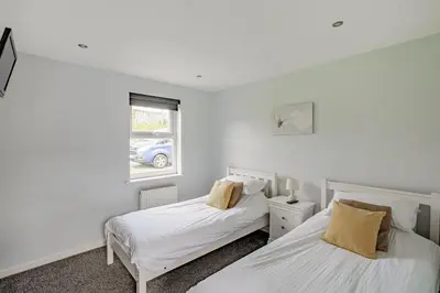 a bedroom with two beds and a window at Auchenlarie Courtyard No 4 in Gatehouse of Fleet
