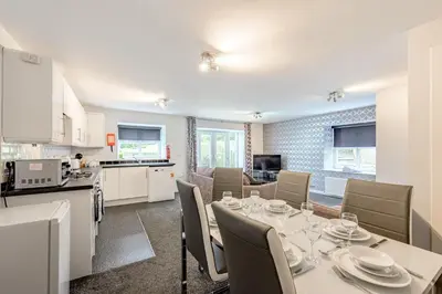 a kitchen and dining room with a table and chairs at Auchenlarie Courtyard No 2 in Gatehouse of Fleet