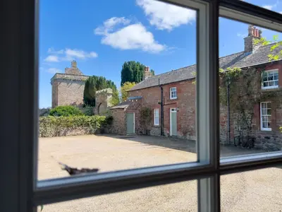 a view from a window of an old building at Kirk House Longtown, ideal for groups or families holidaying together in Longtown