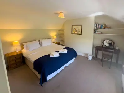 a bedroom with a bed and a table with a chair at Kirk House Longtown, ideal for groups or families holidaying together in Longtown