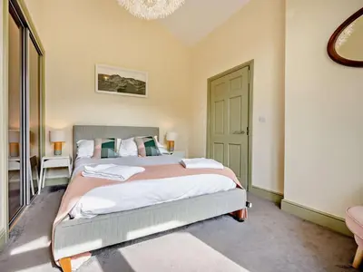 a bedroom with a large bed and a chandelier at 4 Bed in Buttermere oc-sz090 in Buttermere