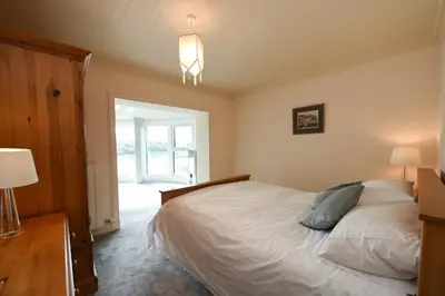 a bedroom with a large bed and a window at Braesyde in Kippford