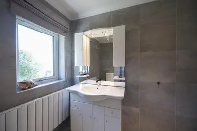 a bathroom with a sink and a window and a mirror at Braesyde in Kippford