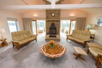 a living room with couches and a fire place at Braesyde in Kippford