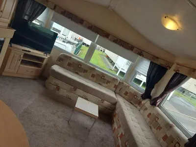 a living room with a couch and a television at Victoria's Caravans in Ayr