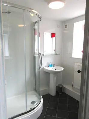 a bathroom with a shower and a sink at Swallow Cottage in Dalbeattie