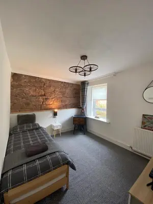 a bedroom with a large bed and a window at Shore Cottage in Girvan