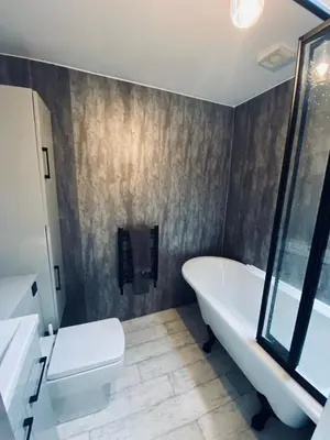 a bathroom with a tub and a toilet and a sink at Shore Cottage in Girvan