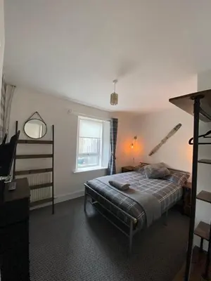 a bedroom with a bed and a window at Shore Cottage in Girvan