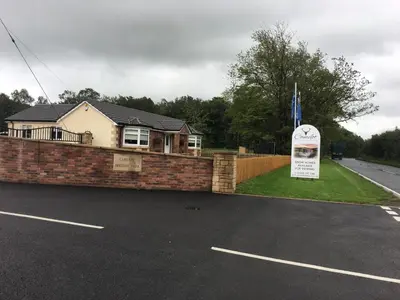 a house with a sign in a parking lot at Carlisle CAMELOT HOLIDAY PARK CA65SZ Blenheim in Longtown