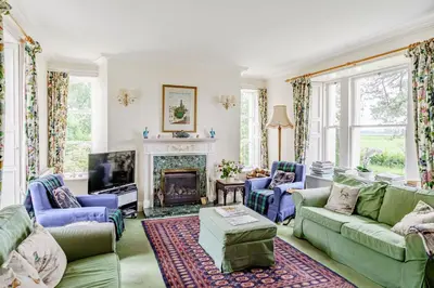 a living room with couches and a fireplace at Bellrigg in Castle Douglas