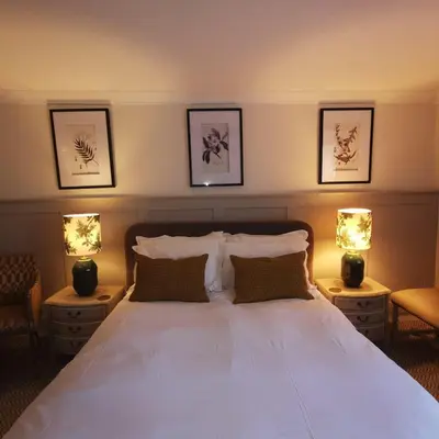 a bedroom with a large white bed with two lamps at The Swinside Inn in Keswick