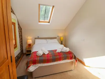 a bedroom with a bed with two towels on it at Gallery Cloisters in Keswick