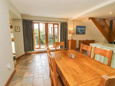 a kitchen and dining room with a wooden table at Gallery Cloisters in Keswick