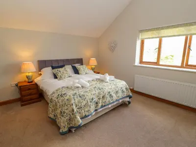 a bedroom with a bed with two towels on it at Gallery Cloisters in Keswick