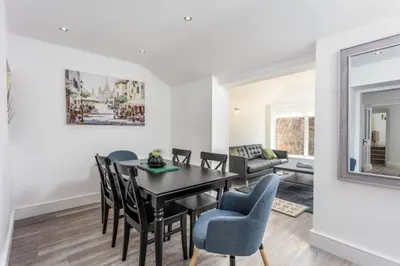 a dining room and living room with a table and chairs at St Meddans Mews in Troon in Troon