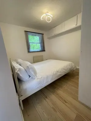 a bedroom with a bed with white sheets and a window at The Ship Inn's Cabin in Gatehouse of Fleet
