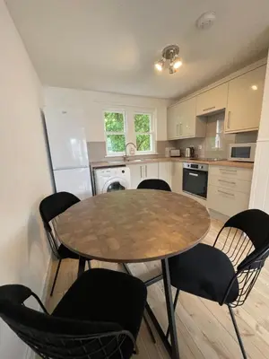 a kitchen with a table and chairs in a kitchen at The Ship Inn's Cabin in Gatehouse of Fleet